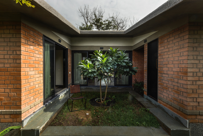 red brickwork encloses the introverted courtyard of urban farm house in india