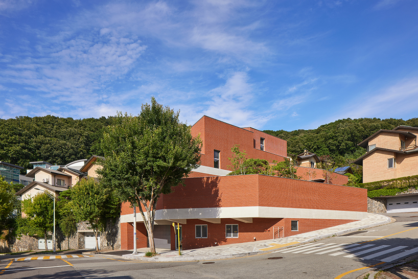 red brick residence in seoul stacks fragmented three-story volume