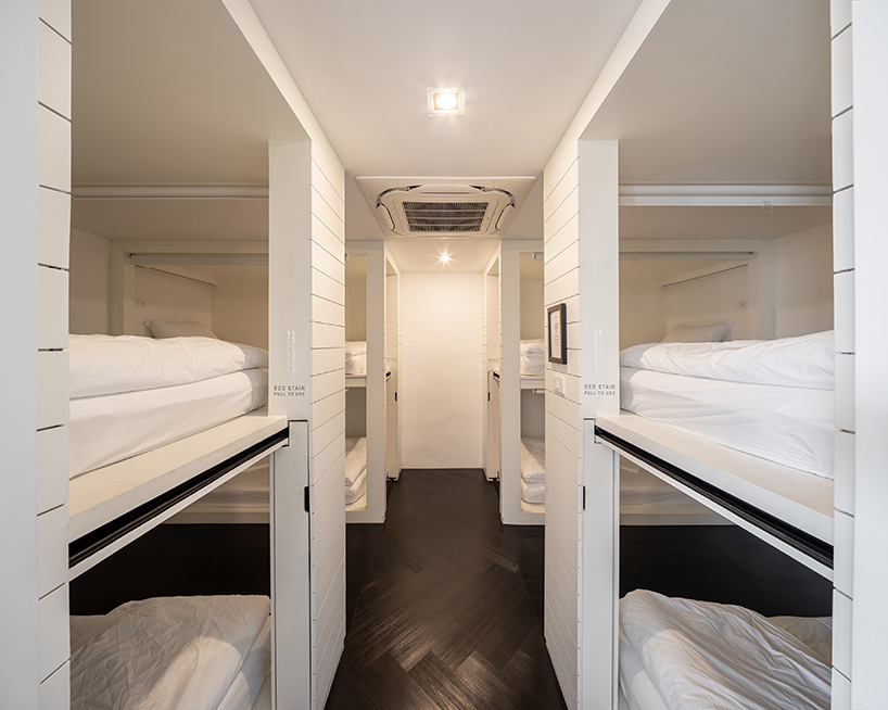 IDIN architects completes pa prank hostel in bangkok with façade of black shutters