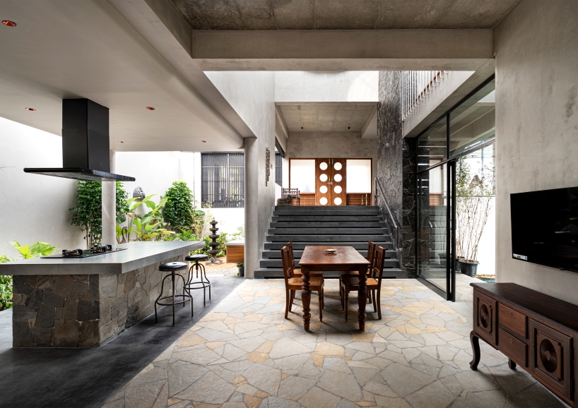 circular green terraces carve through exposed concrete facade in india