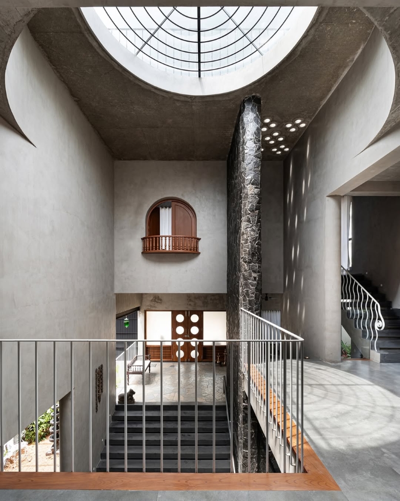 circular green terraces carve through exposed concrete facade in india