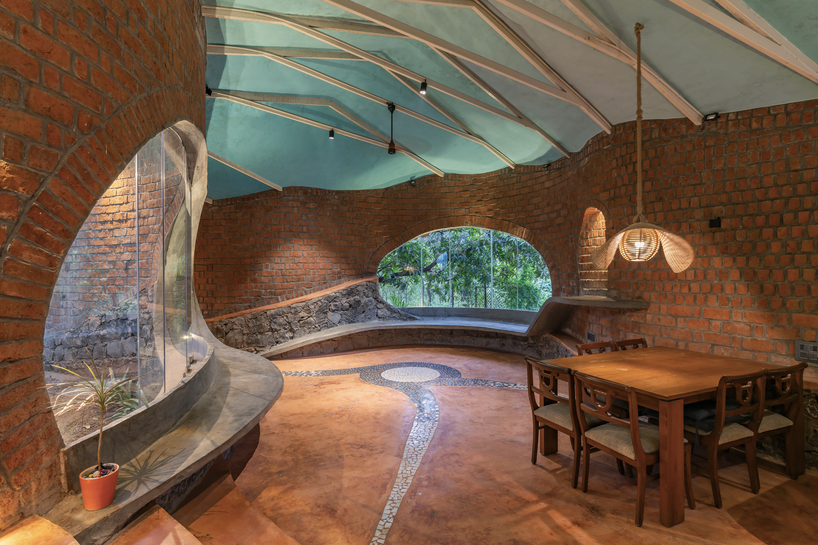 curved brick walls wrap biophilic farmhouse by blurring boundaries in mumbai mangro grove