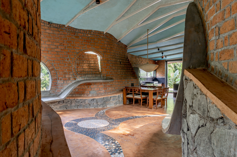 curved brick walls wrap biophilic farmhouse by blurring boundaries in mumbai mangro grove