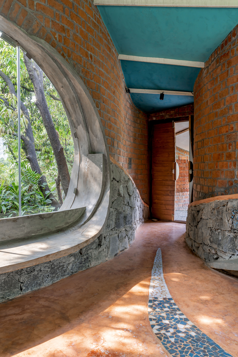 curved brick walls wrap biophilic farmhouse by blurring boundaries in mumbai mangro grove