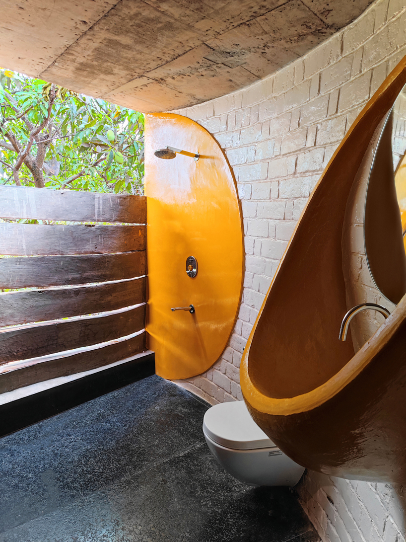 curved brick walls wrap biophilic farmhouse by blurring boundaries in mumbai mangro grove