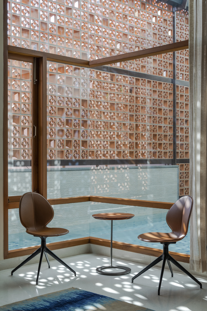 perforated terracotta screens enclose pool pavilion within indian residence