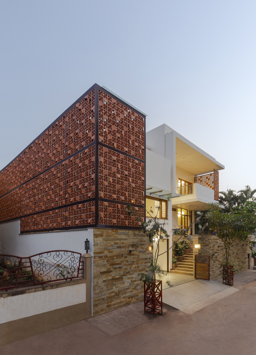 perforated terracotta screens enclose pool pavilion within indian residence