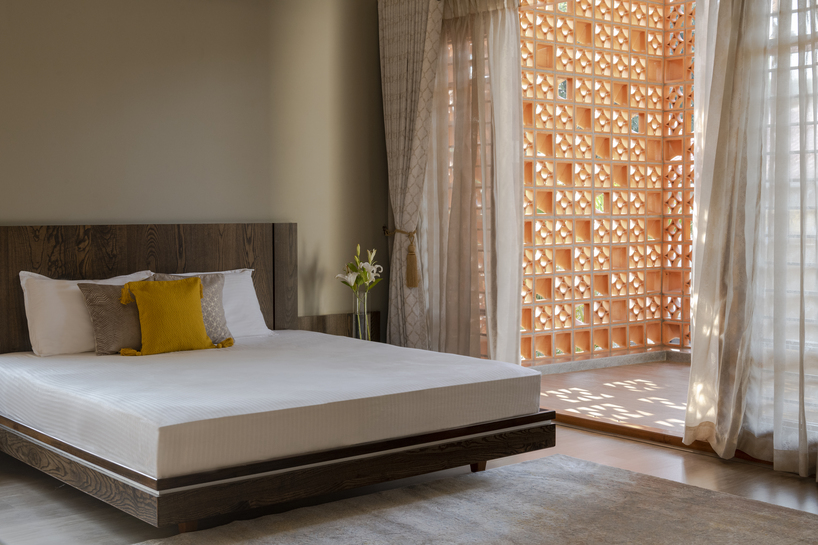 perforated terracotta screens enclose pool pavilion within indian residence