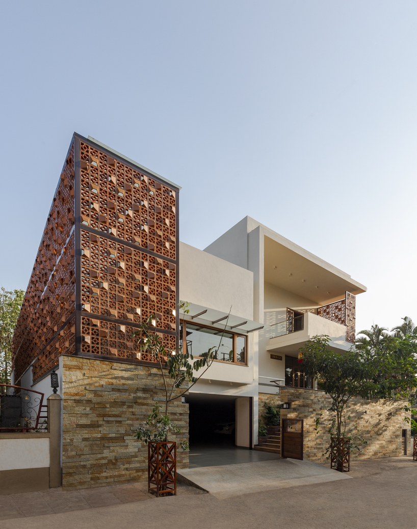 Pantallas de terracota perforadas encierran el pabellón de la piscina en una casa india