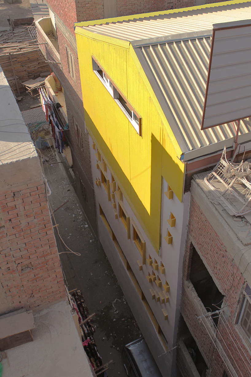 ahmed hossam saafan builds a yellow cultural center in one of cairo's most populated slums