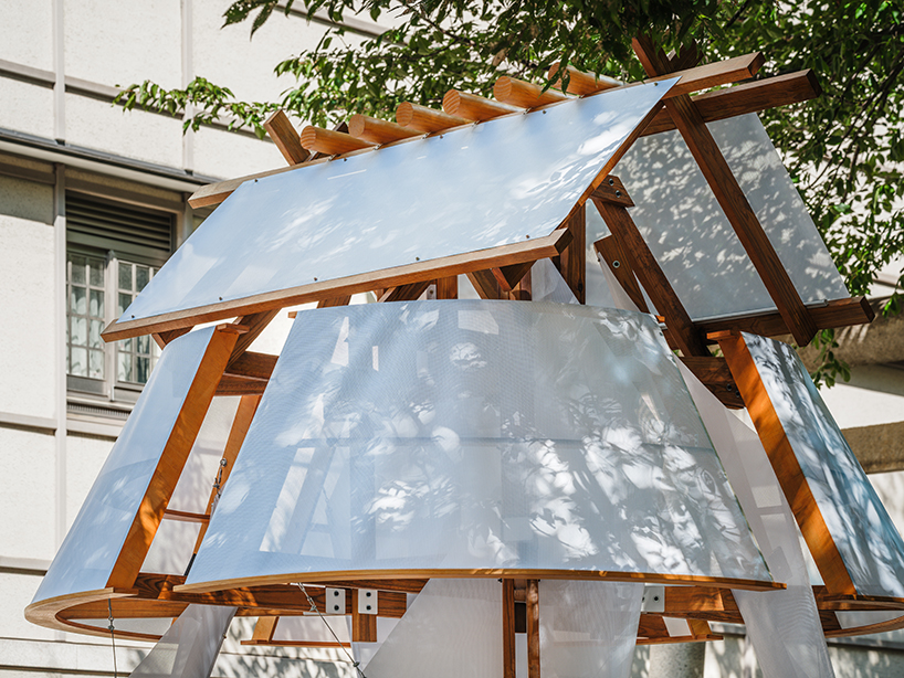 Capas rítmicas de madera y tela se entrelazan en una instalación inspirada en una vela, diseñada por Cheng tsung feng