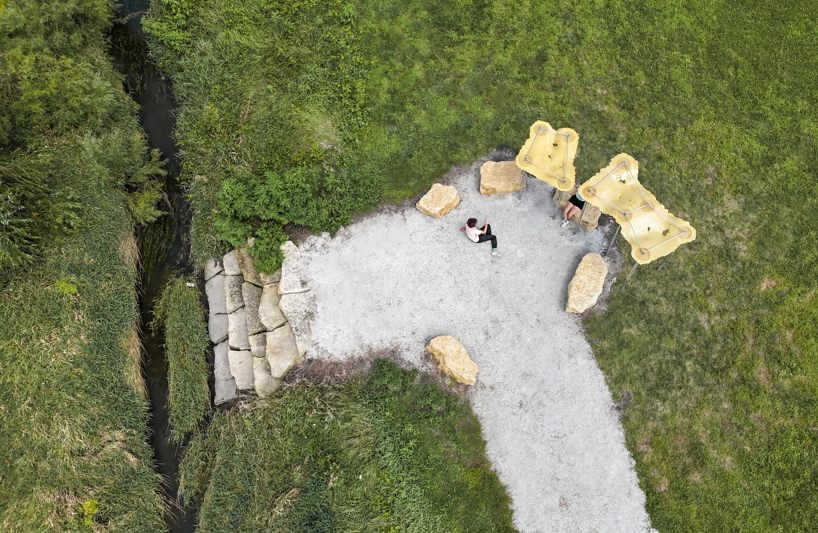 algae-based bio-resin puddle pavilion by i/thee hovers above mud creek in iowa