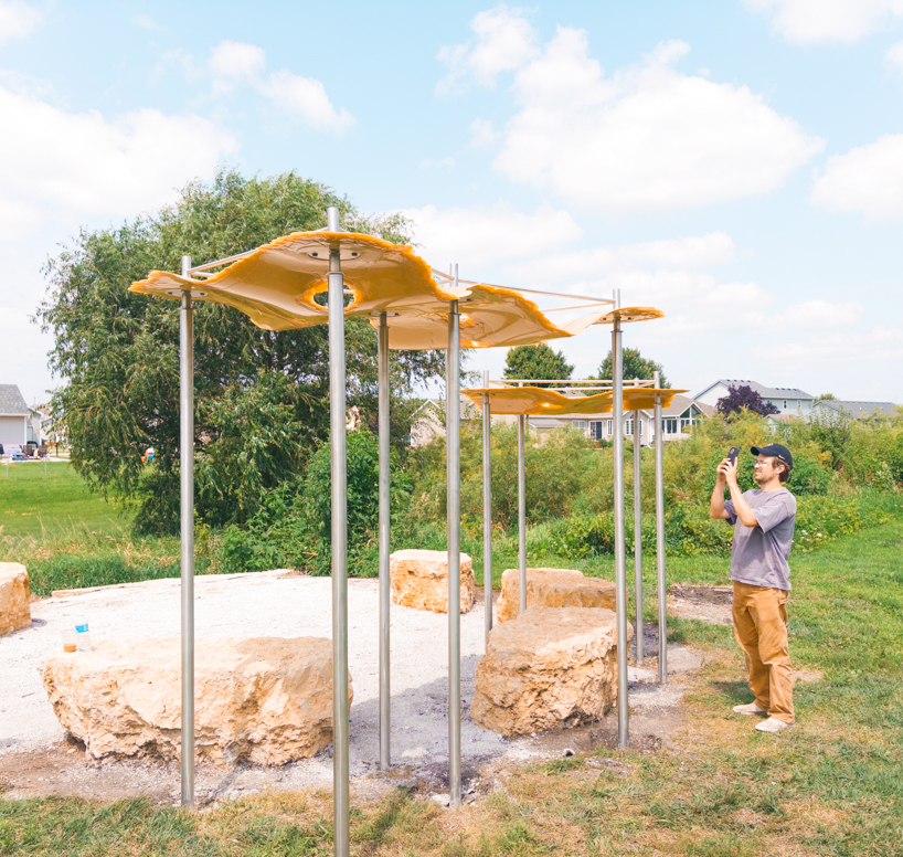 algae-based bio-resin puddle pavilion by i/thee hovers above mud creek in iowa