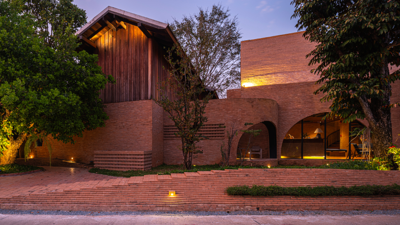 undulating brick facade wraps studio miti's athita pool villa and spa in thailand