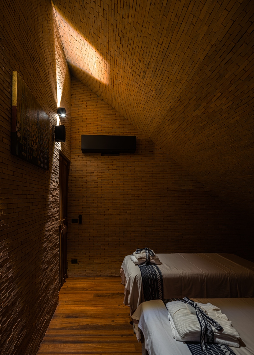 undulating brick facade wraps studio miti's athita pool villa and spa in thailand