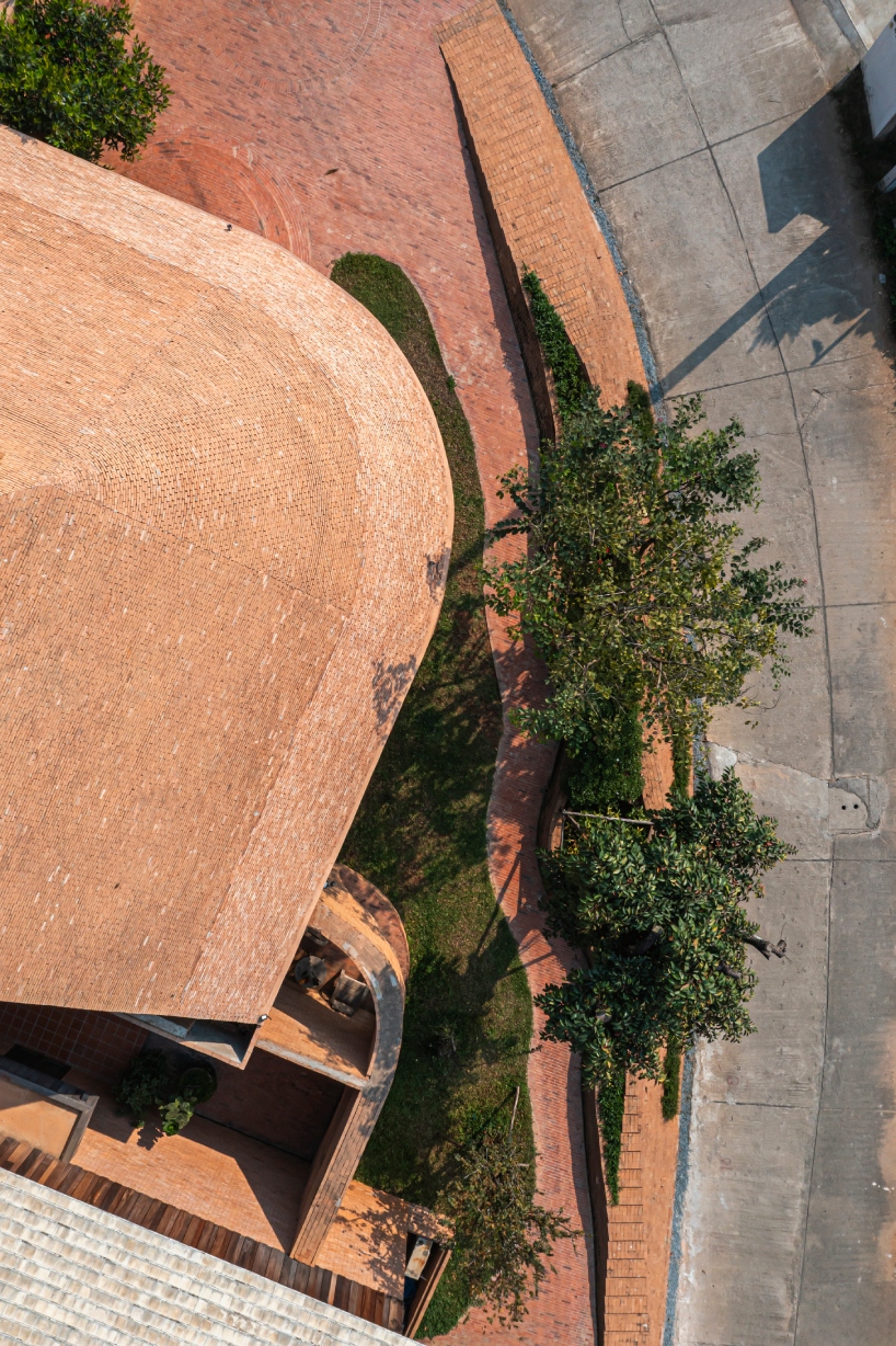 undulating brick facade wraps studio miti's athita pool villa and spa in thailand
