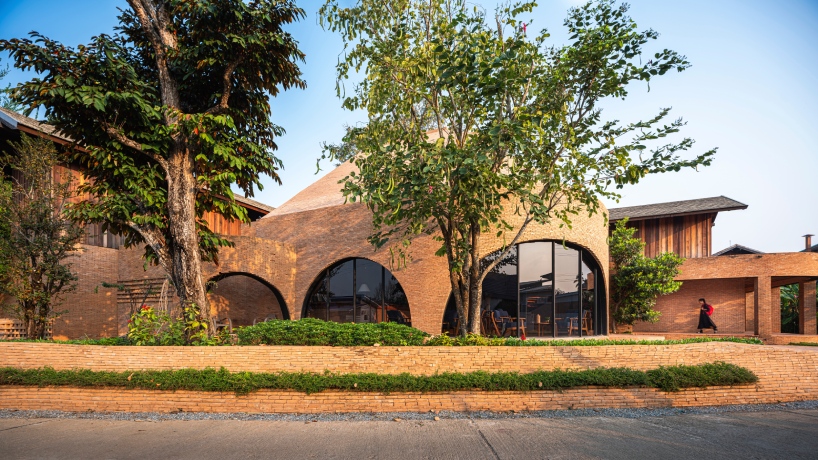 undulating brick facade wraps studio miti's athita pool villa and spa in thailand