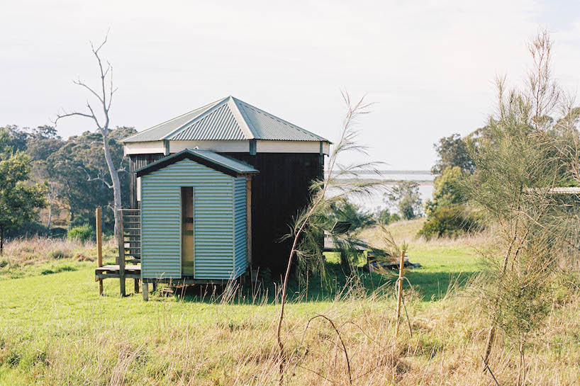 trouthouse revitalizes derelict museum as charred wood cabin in east gippsland, australia