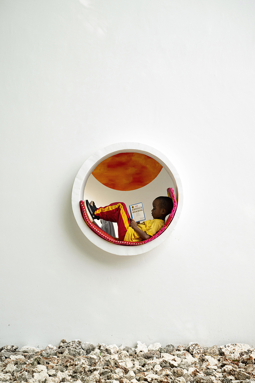 perforated corrugated panels regulate light and ventilation at library in tanzania