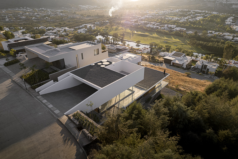 white volumes of jaime juárez's stepped-level house overlook golf course in mexico