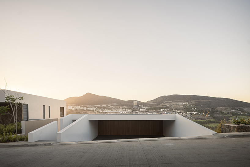 white volumes of jaime juárez's stepped-level house overlook golf course in mexico