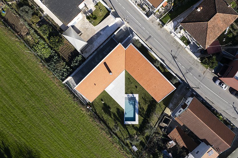 sculptural chimney pierces L-shaped house by martins architecture office in portugal
