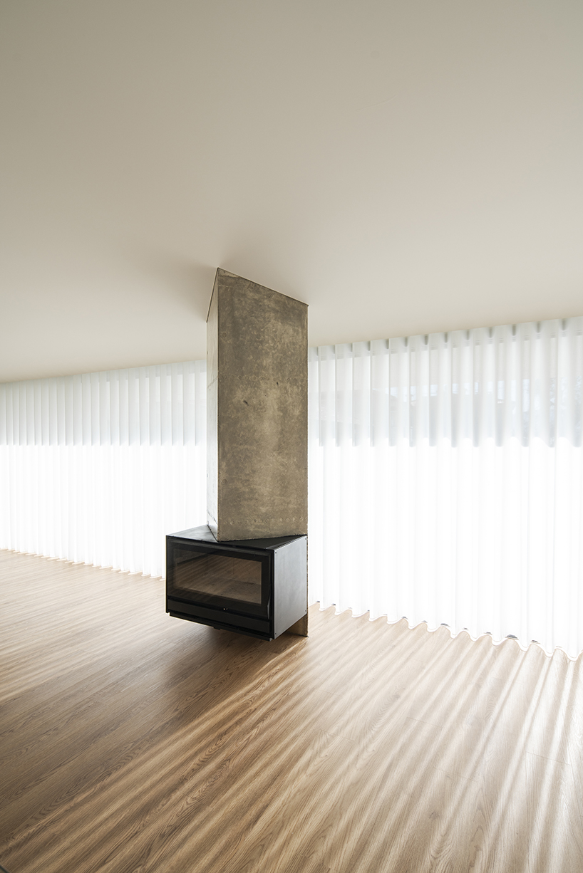 sculptural chimney pierces L-shaped house by martins architecture office in portugal