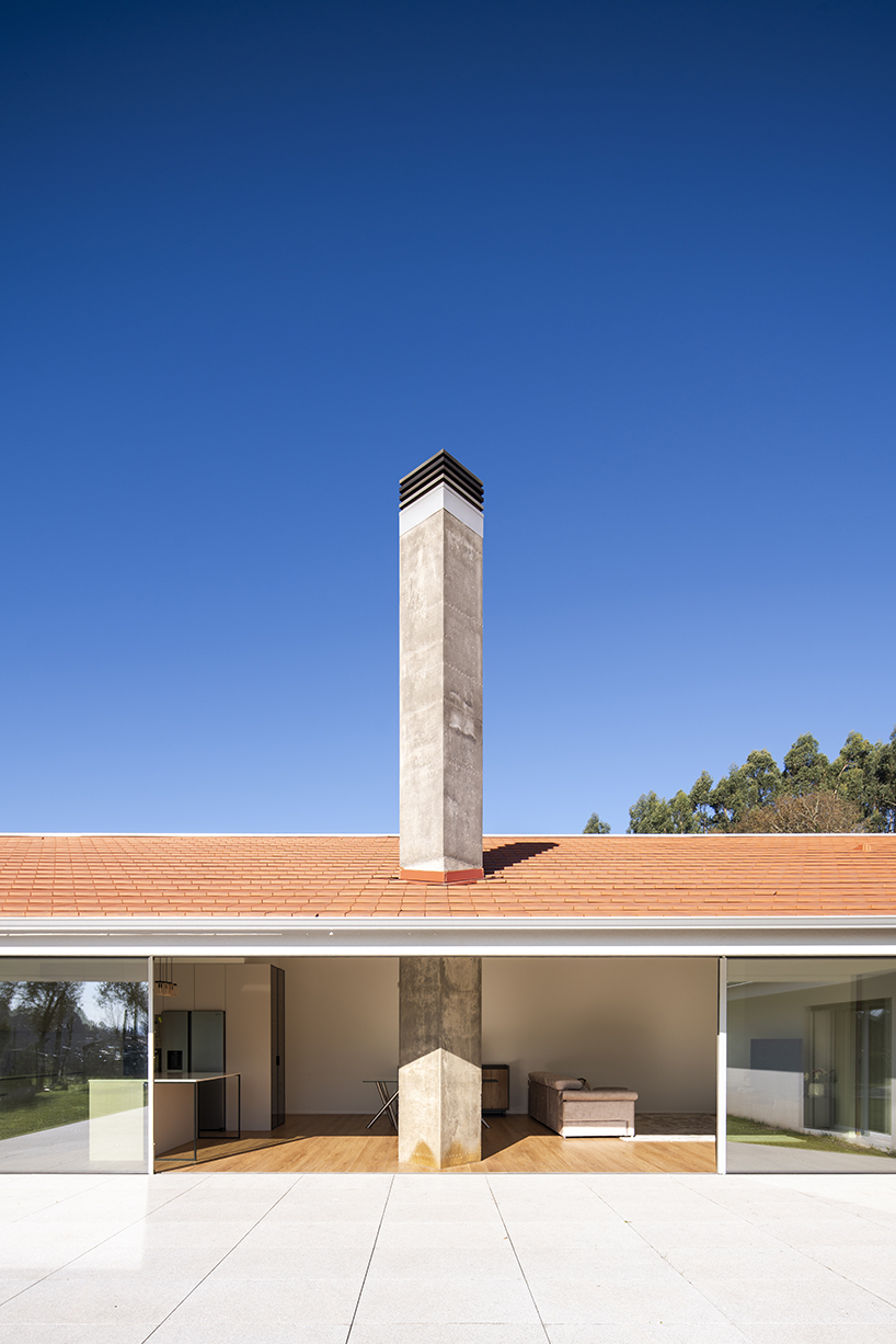 sculptural chimney pierces L-shaped house by martins architecture office in portugal