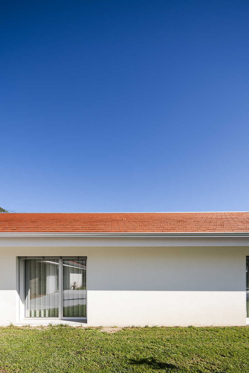 sculptural chimney pierces L-shaped house by martins architecture office in portugal