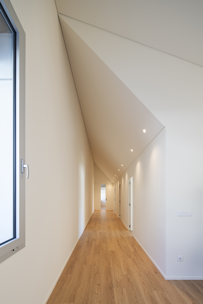 sculptural chimney pierces L-shaped house by martins architecture office in portugal