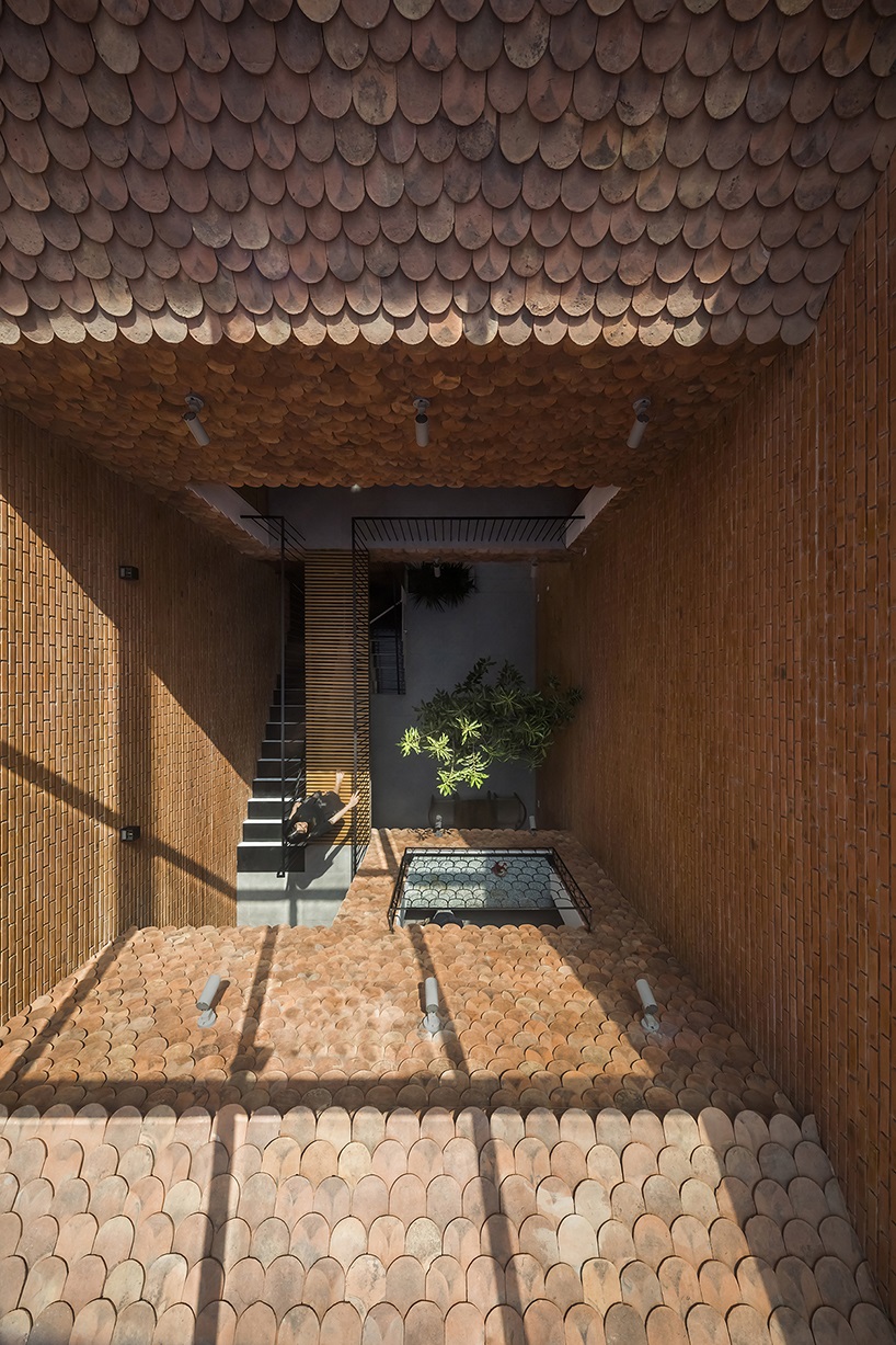 red brick and fish-scale tiles clad this family house by CTA in vietnam