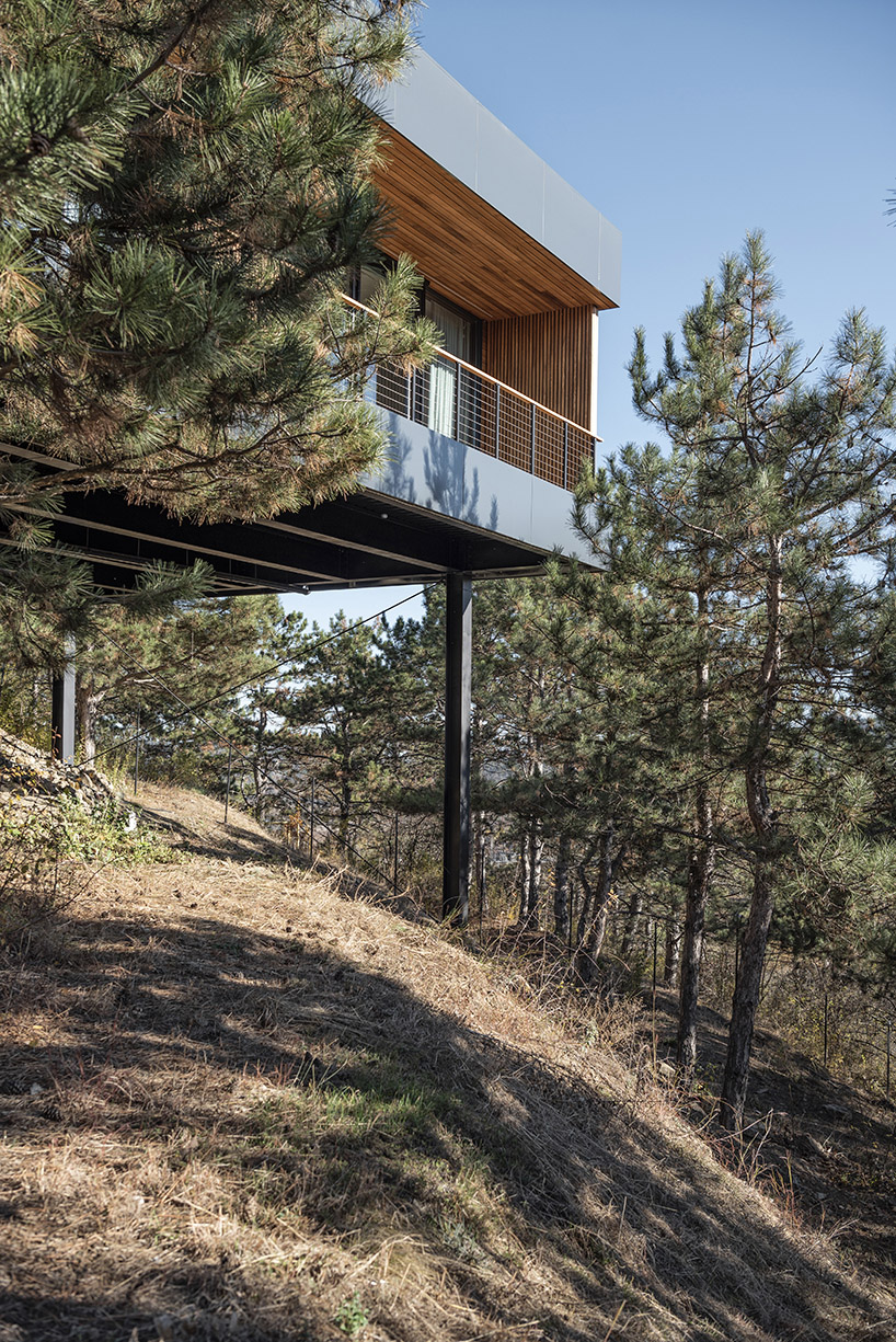 hillside house on stilts by TWO+ preserves natural surroundings