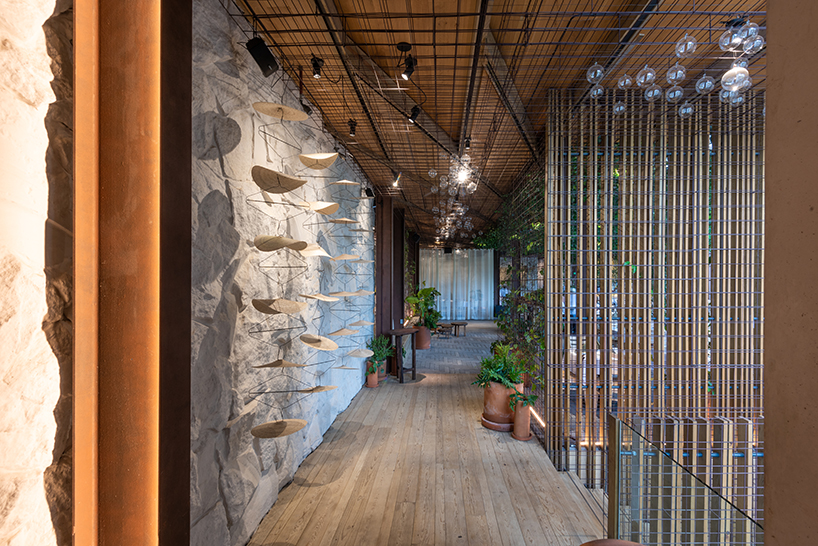 rustic mexican restaurant by territorio arquitectos engulfs diners with a metallic mesh net woven with lush greenery