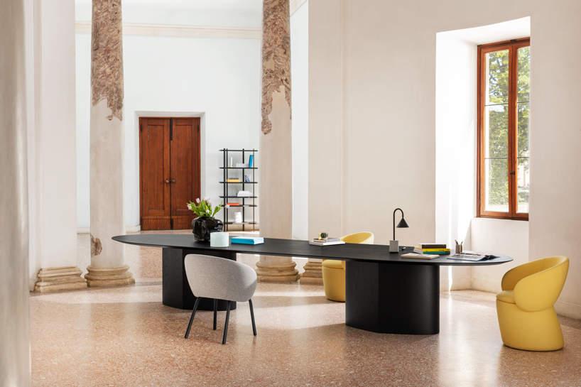 curving tabletops perch atop a monolithic, leaf-shaped base for miniforms' monoplauto table