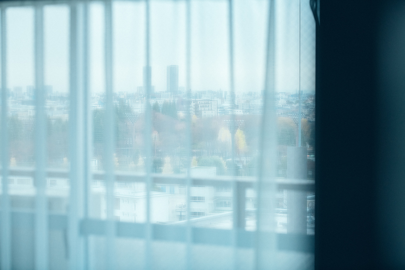 large floating mirror captures urban views within private salon by 2nf+ in tokyo