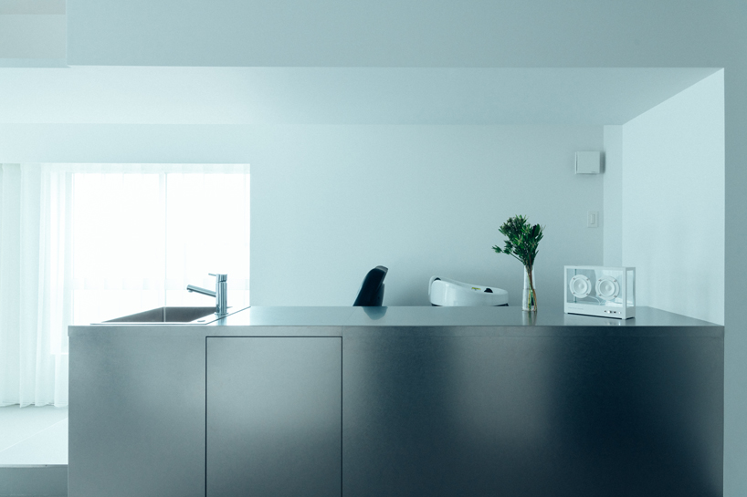 large floating mirror captures urban views within private salon by 2nf+ in tokyo