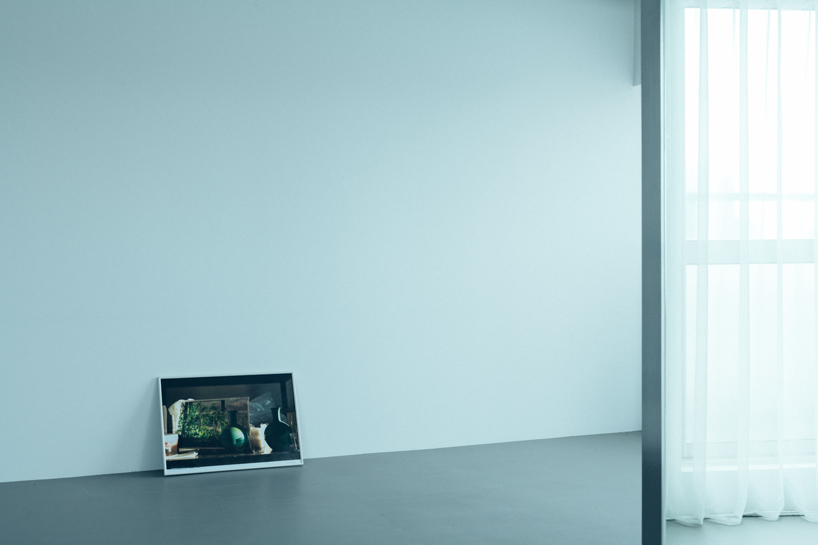 large floating mirror captures urban views within private salon by 2nf+ in tokyo