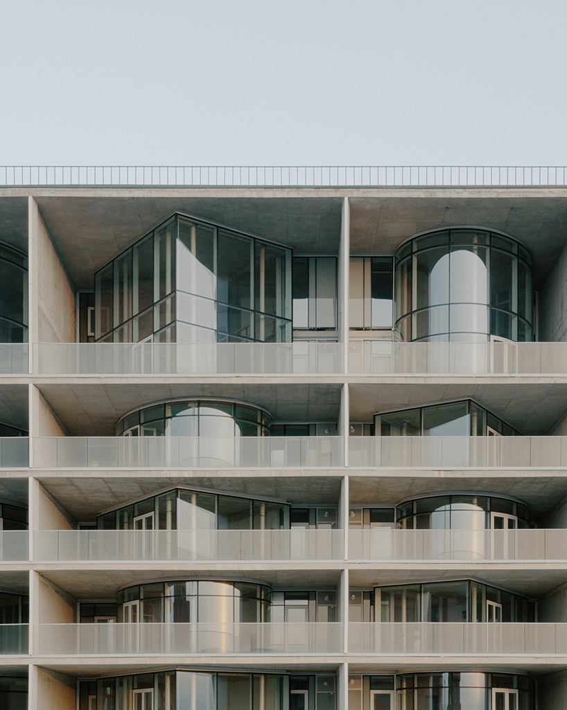 prismatic glass facade enfolds residential unit’s concrete modular framework in georgia