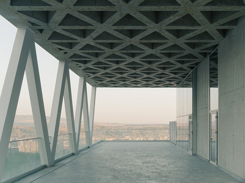 prismatic glass facade enfolds residential unit’s concrete modular framework in georgia