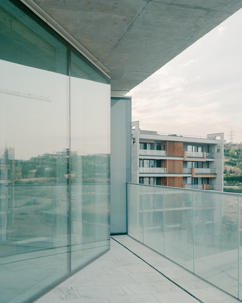 prismatic glass facade enfolds residential unit’s concrete modular framework in georgia