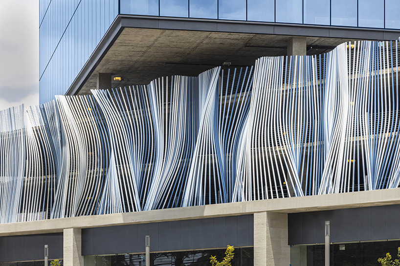 hundreds of aluminum tubes undulate shaping 'ensemble' installation by rob ley