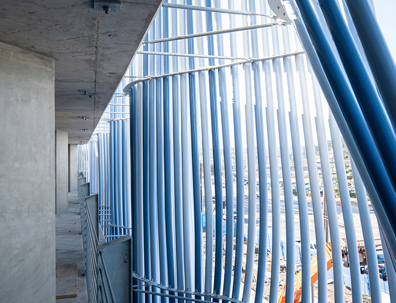 hundreds of aluminum tubes undulate shaping 'ensemble' installation by rob ley