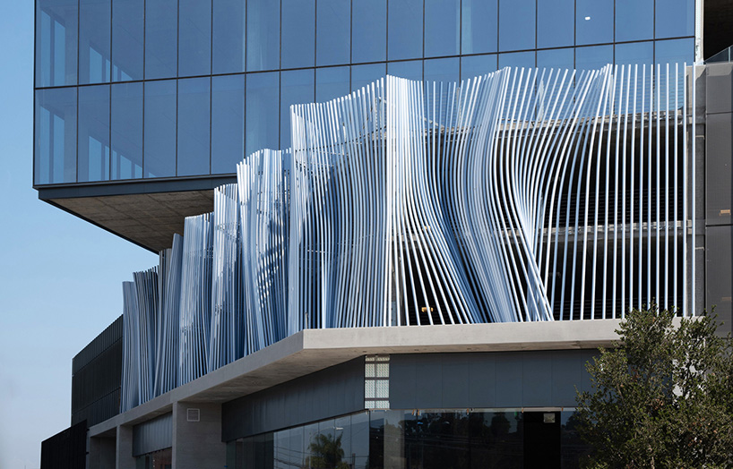 hundreds of aluminum tubes undulate shaping 'ensemble' installation by rob ley