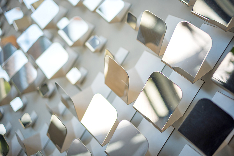 angled mirrored surfaces reveal abstract patterns forming silver lining installation by rob ley