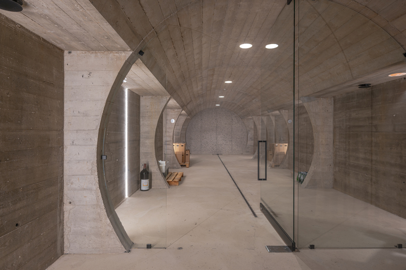 barrel-vaulted concrete cellar organizes vineyard building in poland