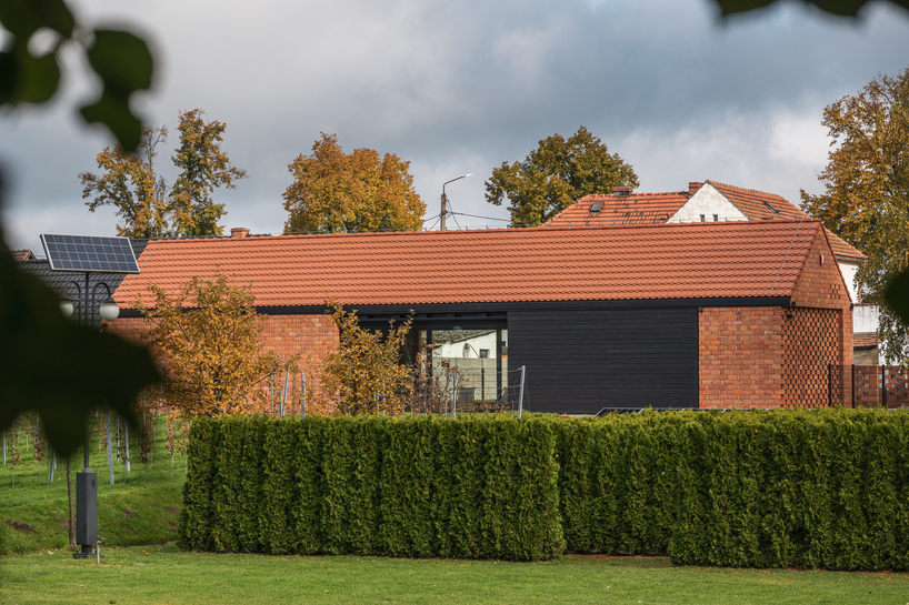 barrel-vaulted concrete cellar organizes vineyard building in poland