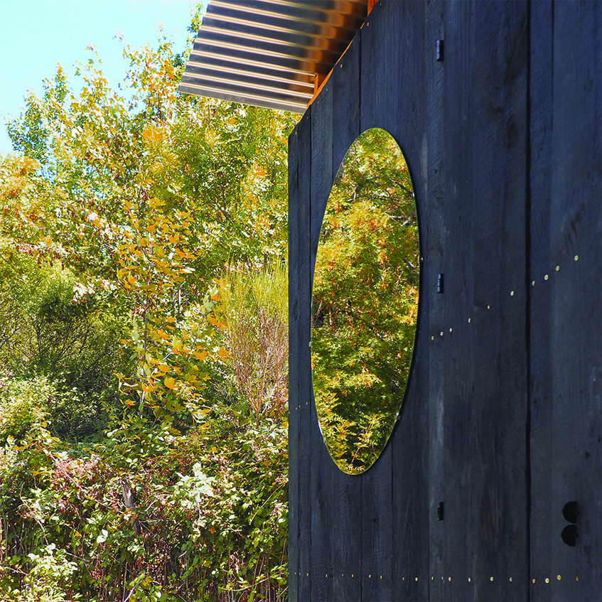 this charred timber sauna by atelier AJO emerges on the shore of french lake