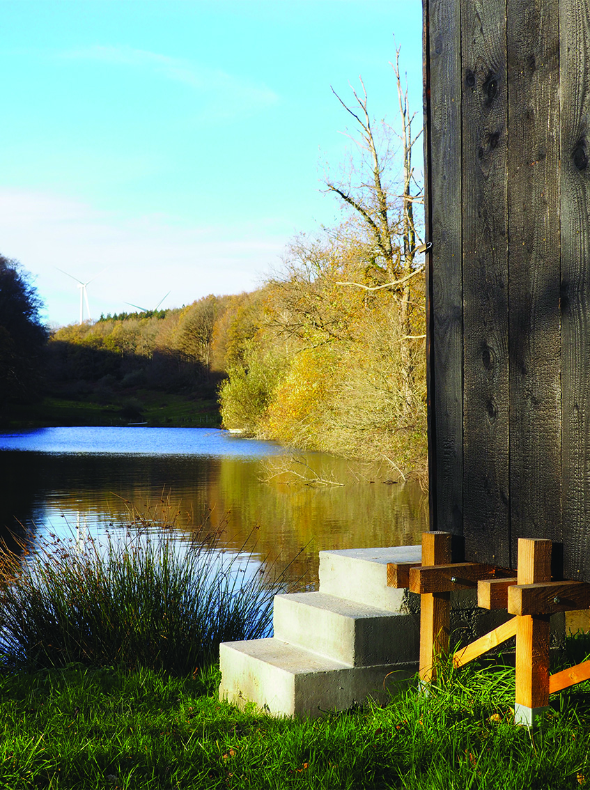 this charred timber sauna by atelier AJO emerges on the shore of french lake