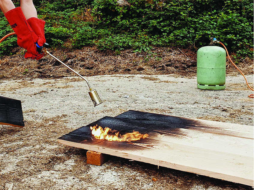 this charred timber sauna by atelier AJO emerges on the shore of french lake