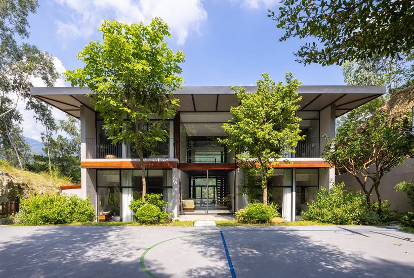 steel frame supports stone-clad ajisai hill house's volumes unfolding in vietnam